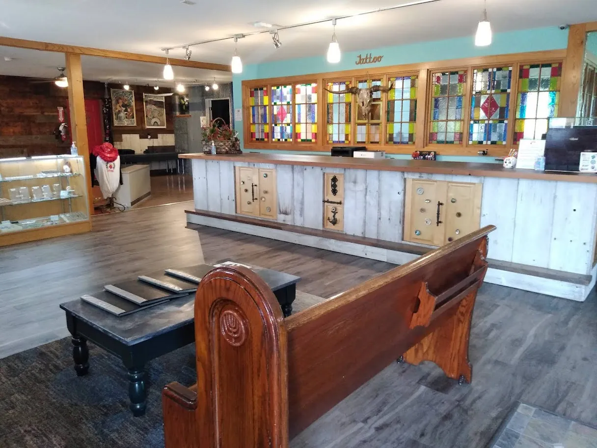 The studio lobby with stained-glass windows and a wooden church pew