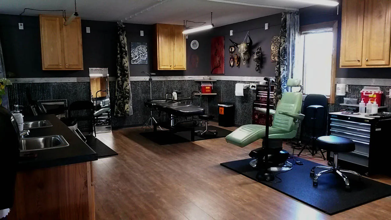 A tattoo station at Crimson Heart Designs with a green client chair
